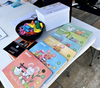 Stoisko warsztatów języka angielskiego dla dzieci z książeczkami edukacyjnymi, materiałami do zabawy.
