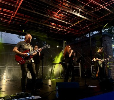 Zespół Przystanek Mrówkowiec wykonuje rockowe przeboje podczas wieczornego koncertu dla publiczności zgromadzonej w Forcie Borek.